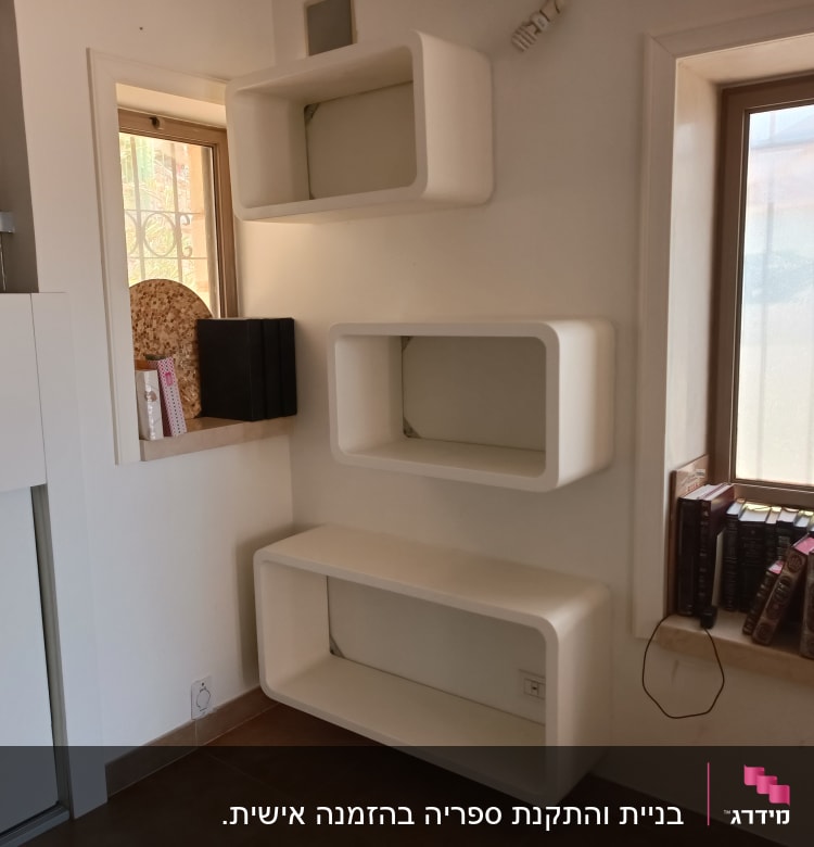 מדפים לבנים מותקנים על קיר ליד חלון